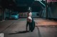 A naked woman walking down a street at night.