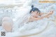 A woman laying in a bathtub covered in foam.