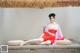 A woman in a red dress sitting on a wooden platform.