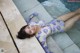 A woman laying on the edge of a swimming pool.