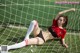 A woman in a bikini laying on a soccer field.