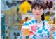 A woman in a kimono holding a cup of orange juice.