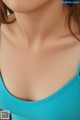 A close up of a woman wearing a blue tank top.